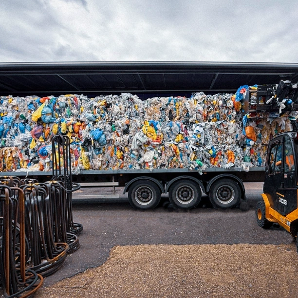 Bales of plastic being loaded into an articulated lorry for recycling.