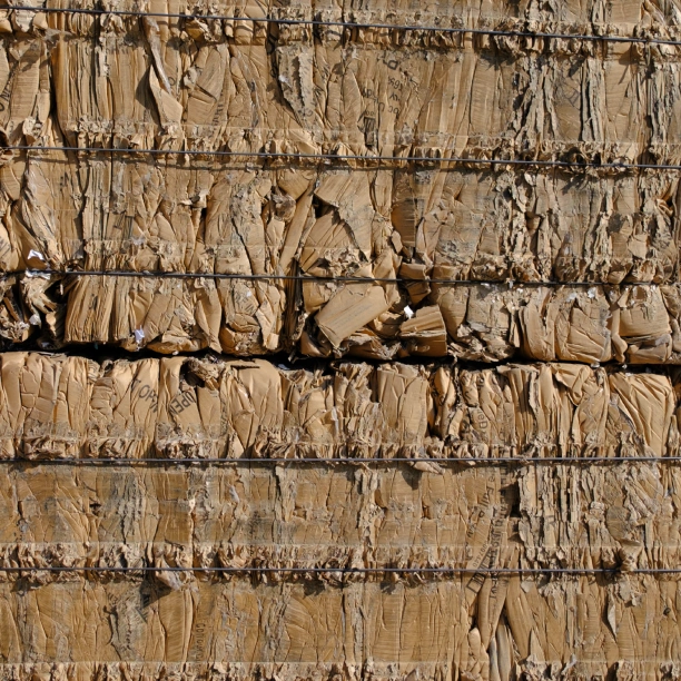 Compressed cardboard bales contained with baling wire.