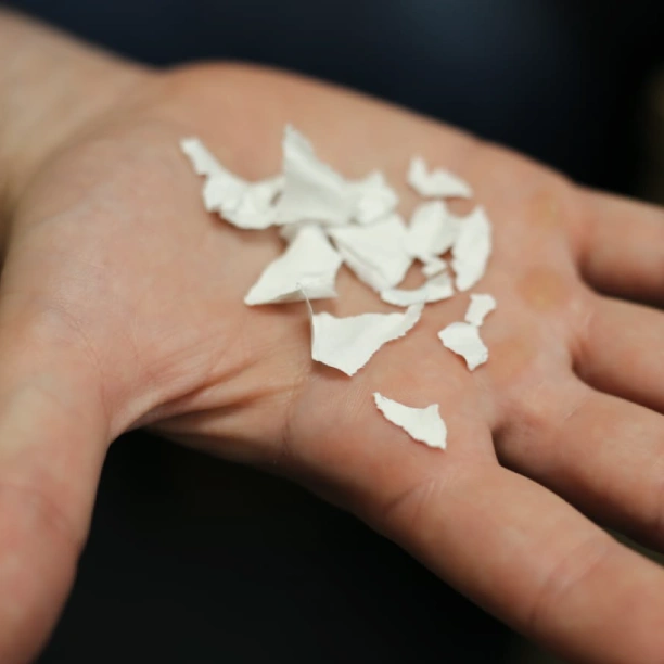 Small fragments of ripped paper in the palm of a hand.