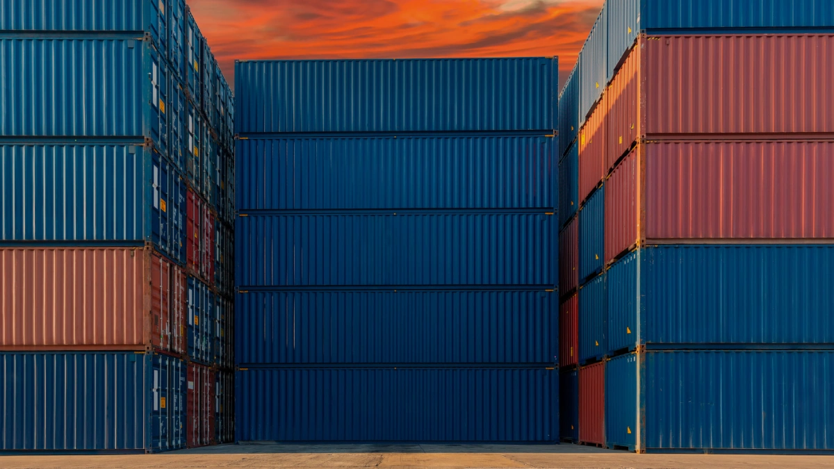 Stacks of blue and orange cargo shipping containers.