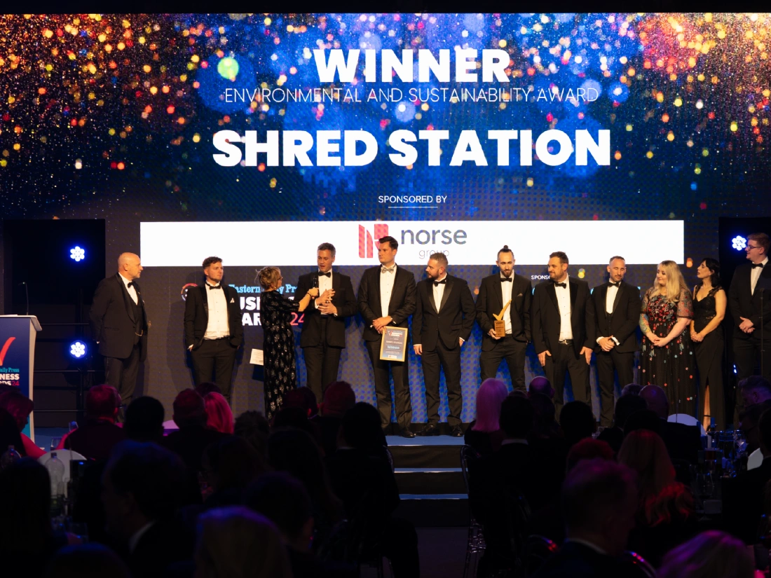 Shred Station staff receiving an award on stage.