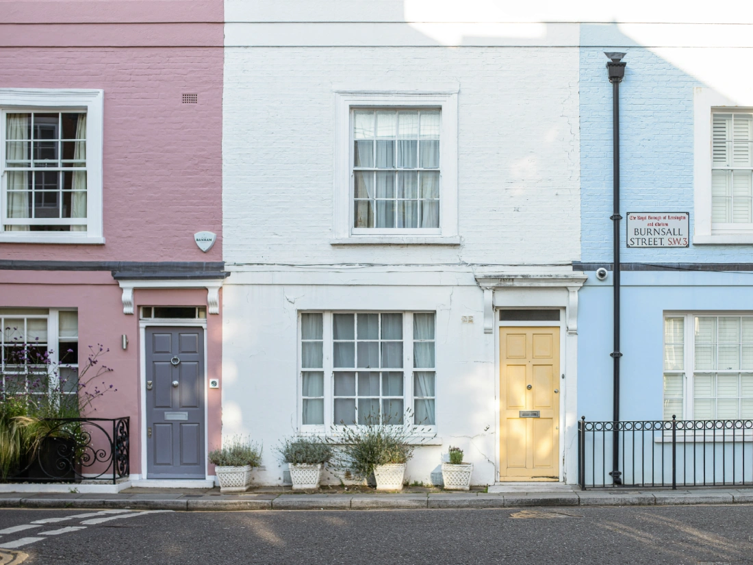 Row of houses painted with pastel pink, white, and blue exterior walls.