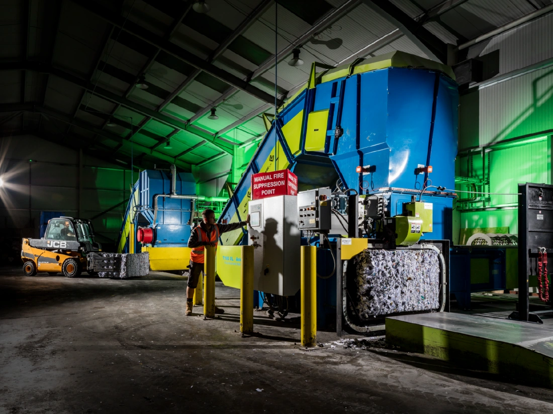 An industrial shredding machine and paper baler at one of Shred Station's high-security facilities.