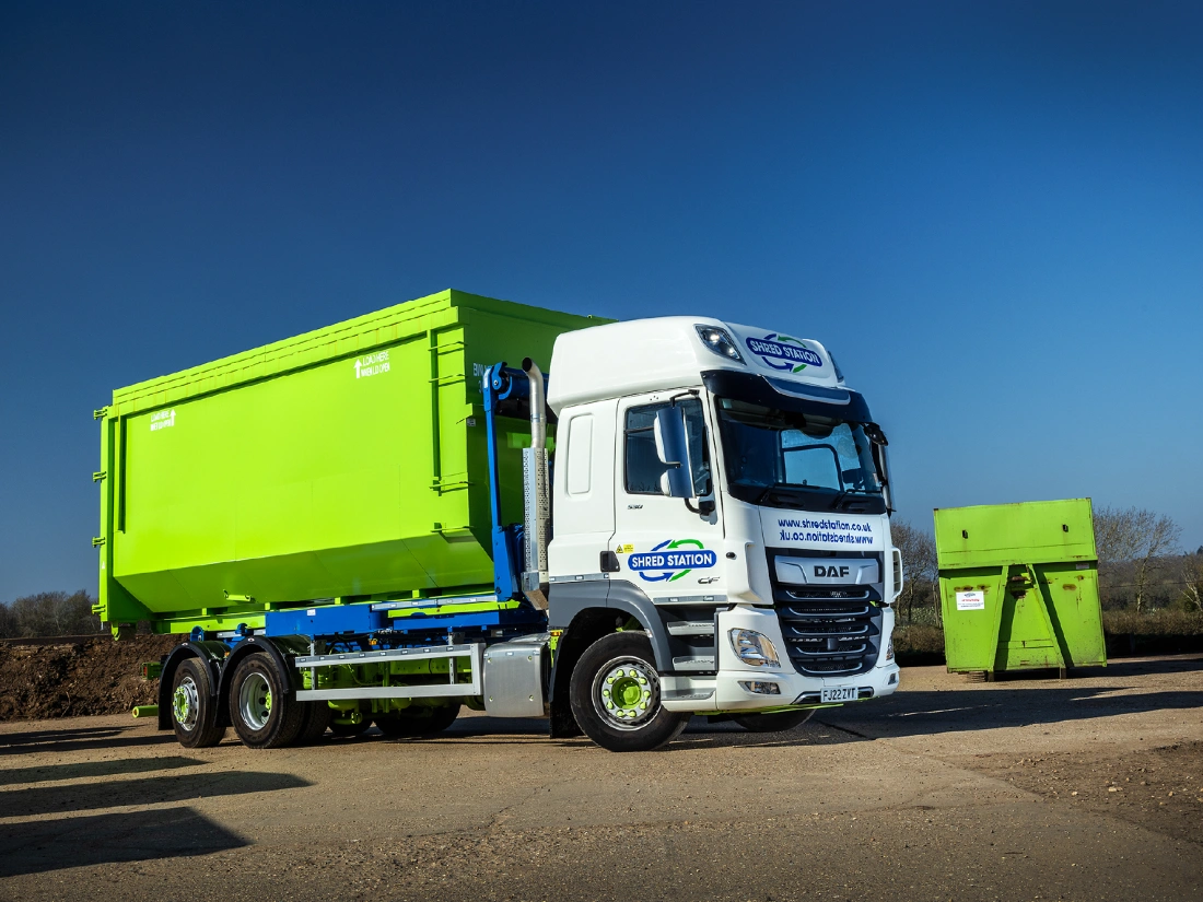 RORO skip truck with lime green skip attached via hooklift.