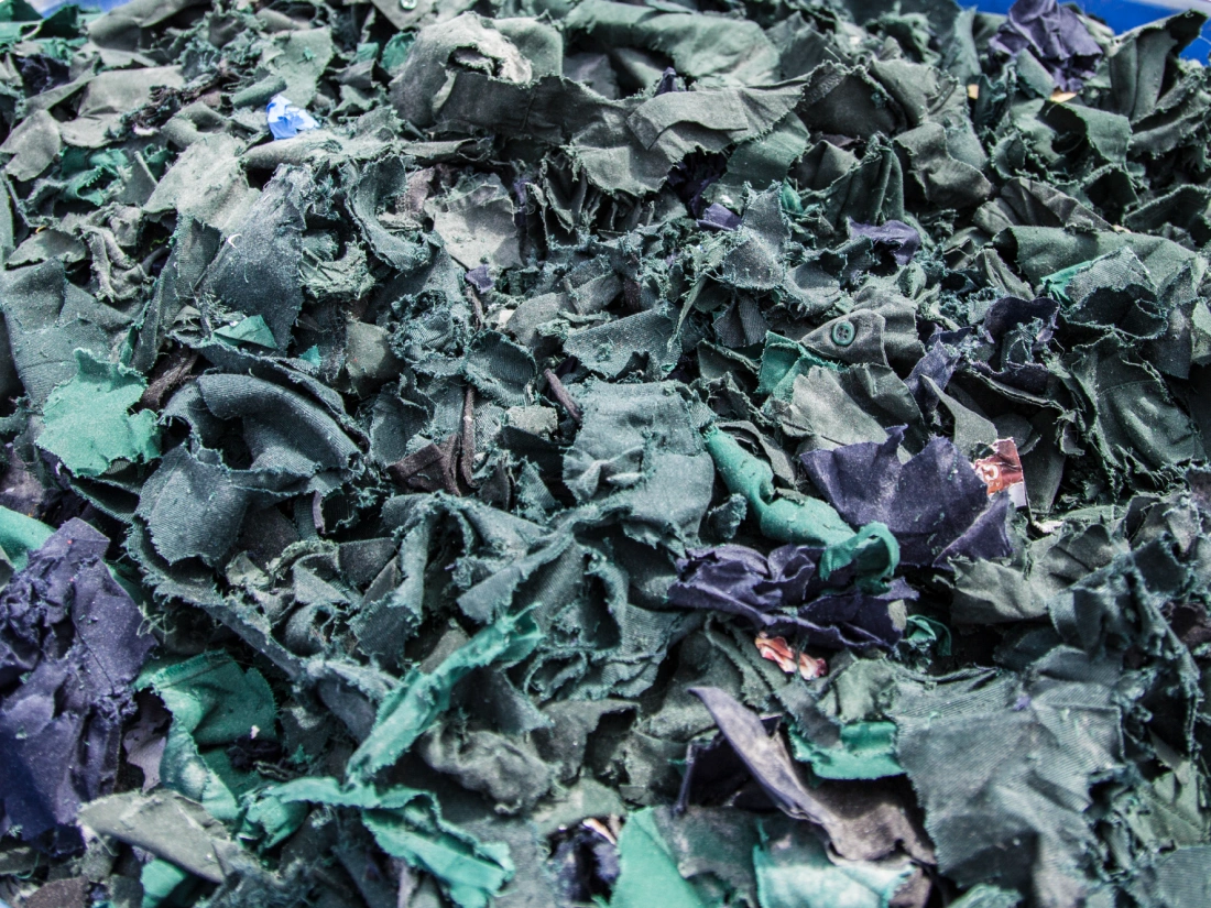 Pile of green and blue shredded textiles.