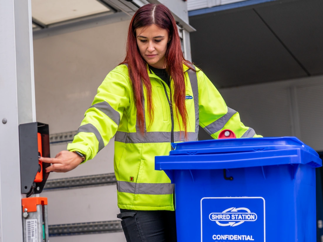 Shred Station operative loading a bin full of confidential paperwork onto a secure vehicle.
