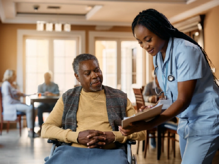 A doctor showing a patient in a wheelchair a piece of paper.