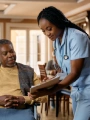 A doctor showing a patient in a wheelchair a piece of paper.