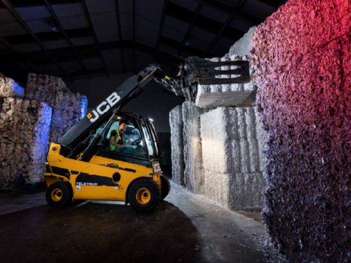 Forklift moving a bale of shredded compressed paperwork.