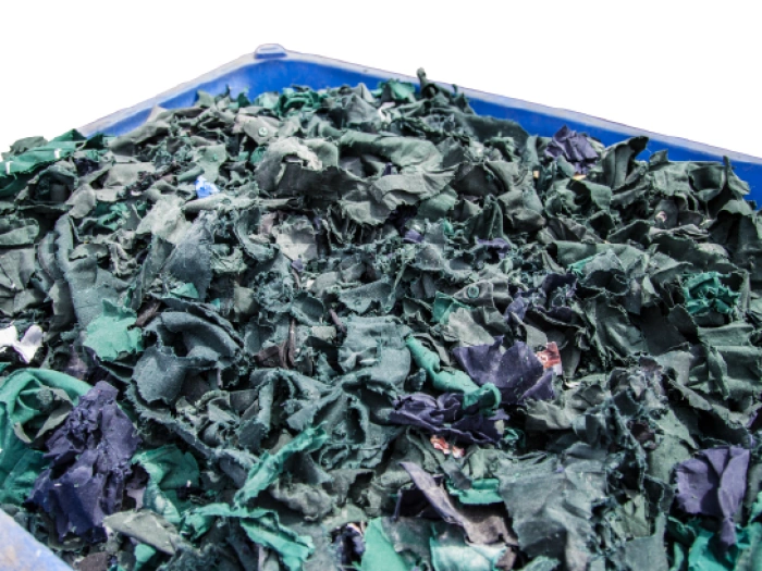 Plastic dolav box of shredded blue and green textile uniforms.