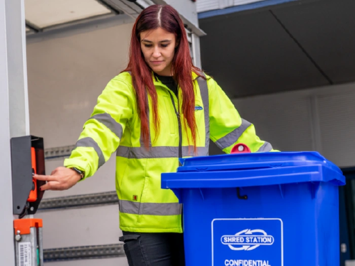 Shred Station operative loading a bin full of confidential paperwork onto a secure vehicle.