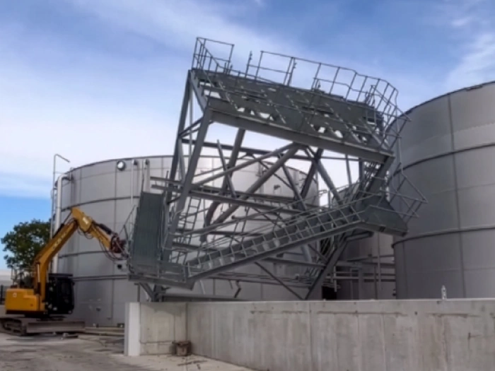 Large metal structure being demolished.