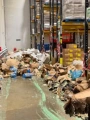 A warehouse floor with hundreds of spilled and crushed cardboard boxes.