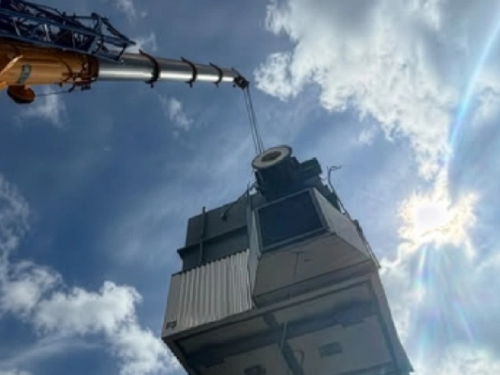 A crane moving a large piece of machinery.