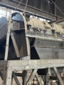 Large piece of machinery being removed from warehouse with chain lift.