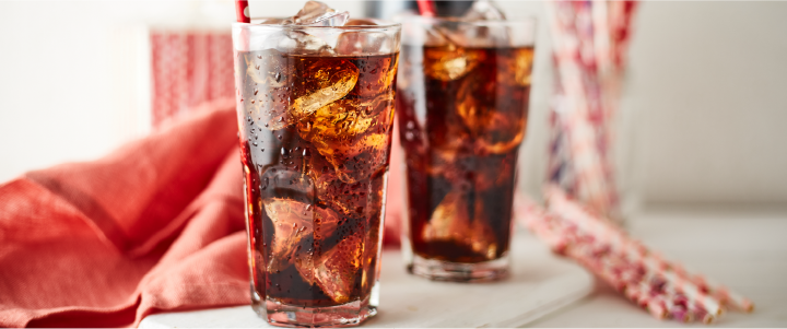 Image of fizzy brown cola liquid drink in a glass with ice