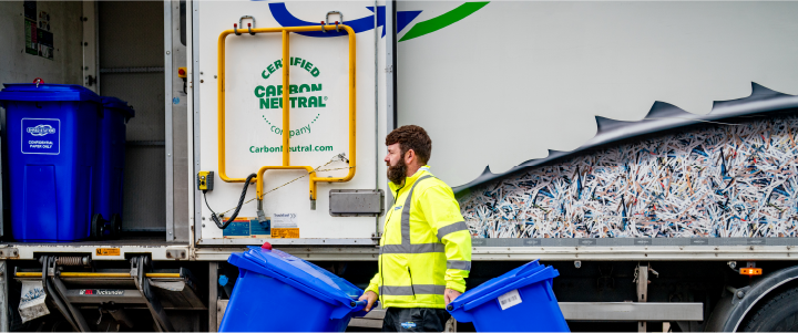 Shredding service worker pulling confidenial waste bin 
