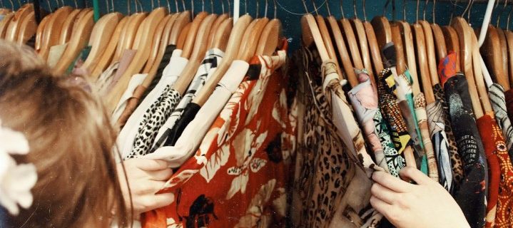 Image of woman looking through garments on a clothing rail