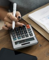 Image of woman's hand pressing numbers on a calculator