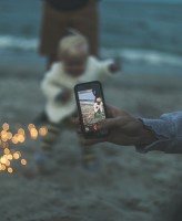 taking photo of child on beach sharenting