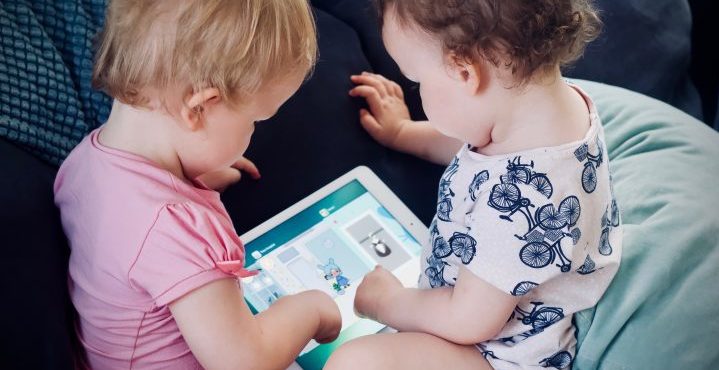 Image of two toddlers playing on an ipad