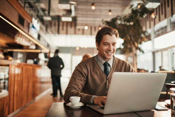 man working from cafe on laptop