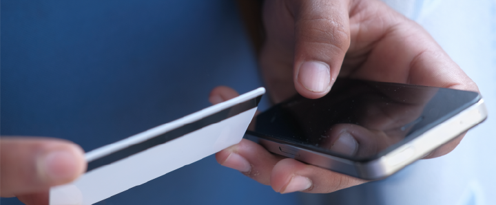 Image of hands holding a mobile phone and credit card